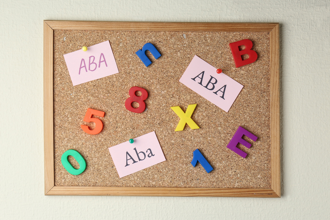 Applied Behavior Analysis Concept. Paper Notes with Abbreviation ABA, Colorful Letters and Numbers on Corkboard